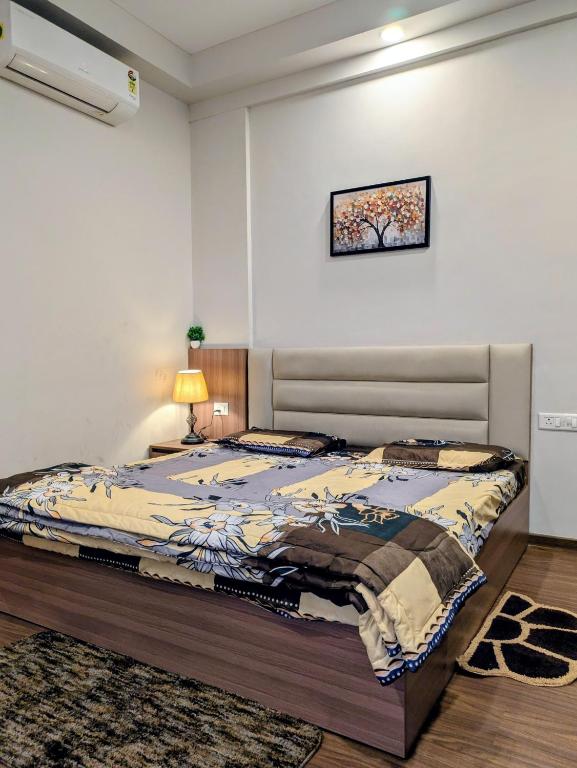 a bedroom with a bed and a lamp on a table at Home Bliss BnB in Greater Noida