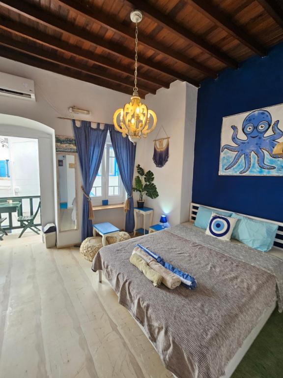a bedroom with a large bed with a blue wall at Octopus Blue in Mikonos