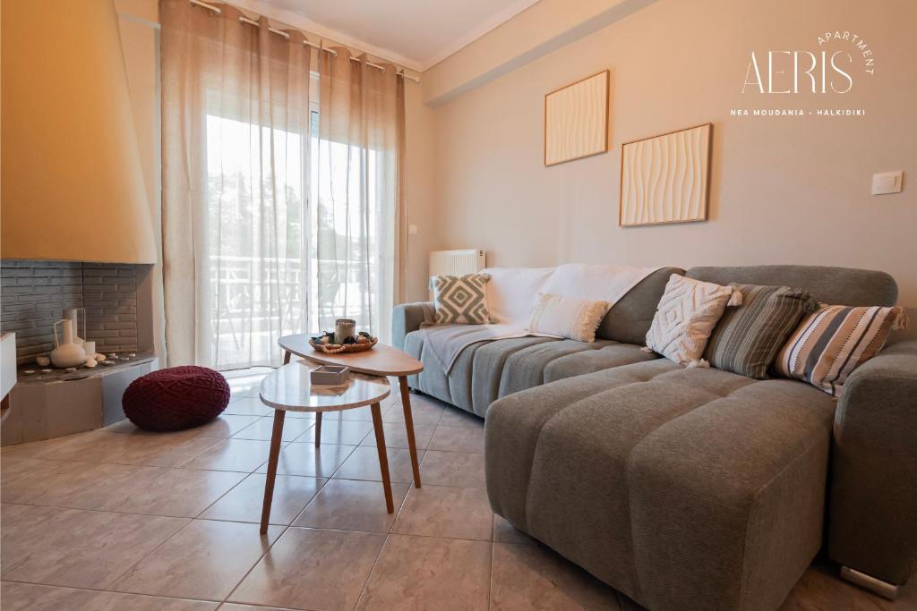 a living room with a couch and a table at Aeris Apartment by Booking Kottas in Nea Moudania