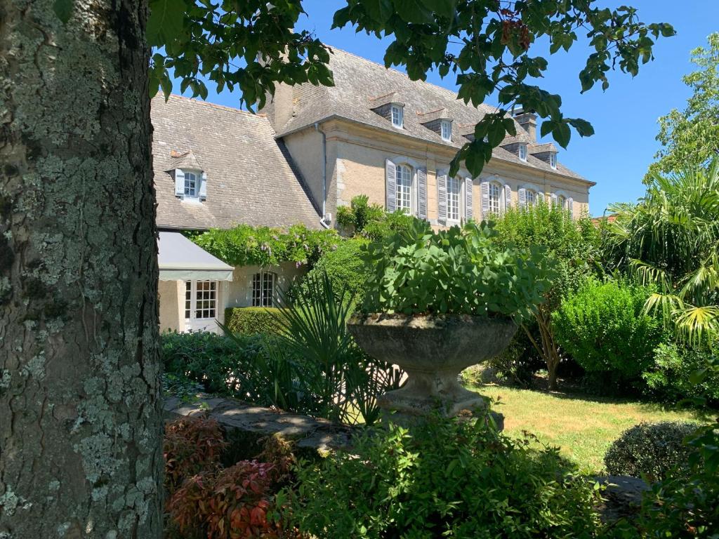 a large house with a fountain in the yard at Maison Thoumieu in Azereix
