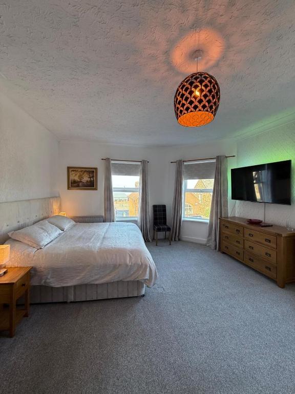 a bedroom with a bed and a flat screen tv at Crispin House in Hunstanton