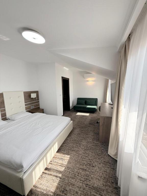a bedroom with a large bed and a couch at White Residence in Arad