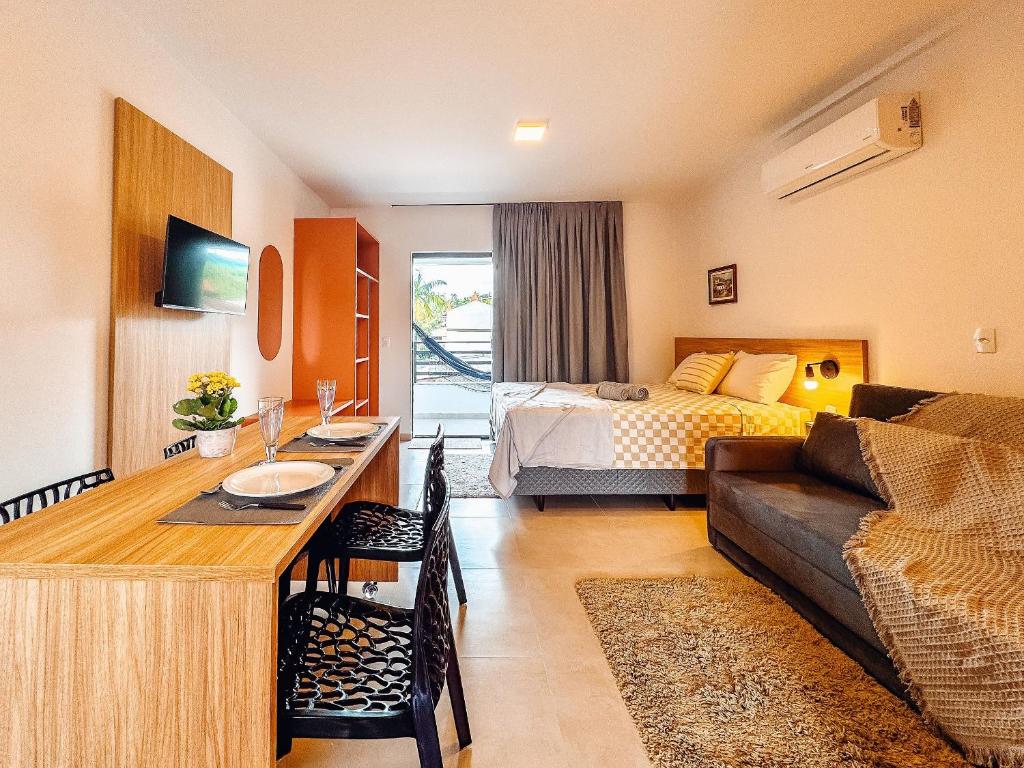 a hotel room with a bed and a living room at Centro | Studio Completo até 4 pessoas in Brusque
