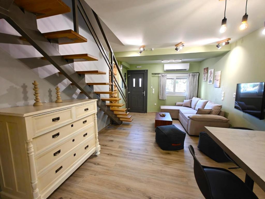 a living room with a staircase and a couch at Aria home in Tsoukalades
