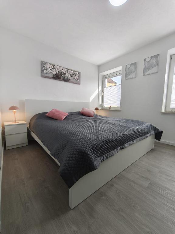 a bedroom with a large bed in a white room at The Günz Homes 2 in Günzburg