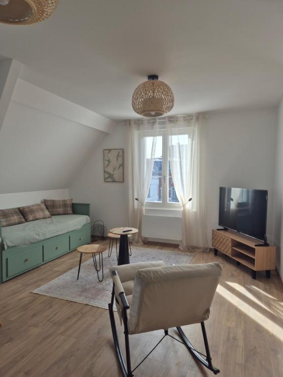 a living room with a couch and a tv at le St fursy 31 in Péronne