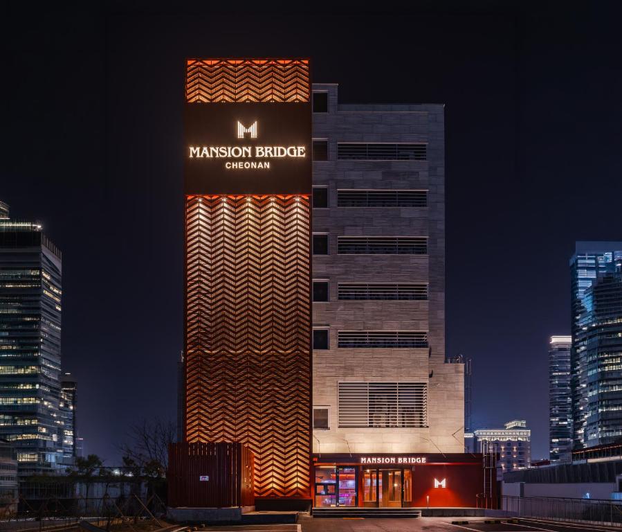 a building with a sign on the side of it at Mansion Bridge Cheonan in Cheonan