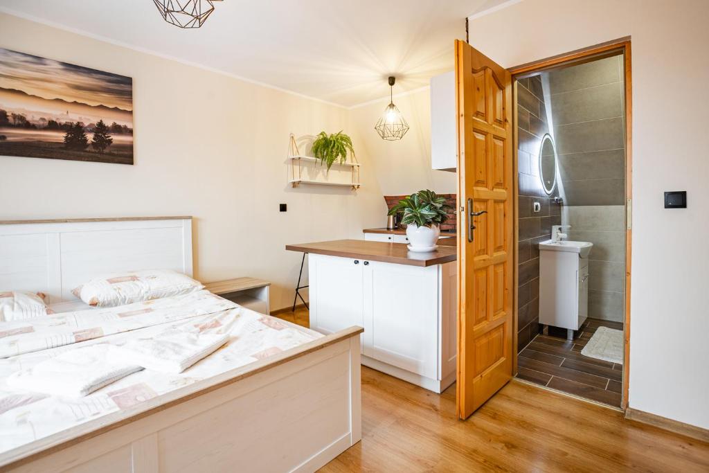 a bedroom with a bed and a bathroom at Agrozacisze in Zubrzyca Górna