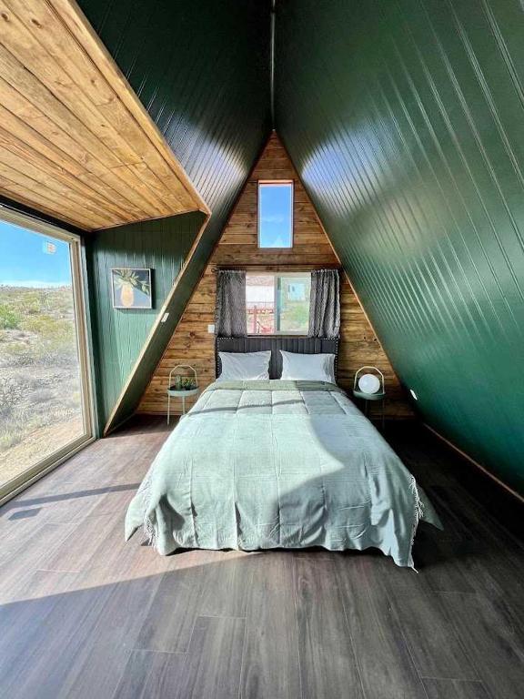 a bedroom with a large bed in a green room at Starwalk Modern A-Frame #1 in Meadview