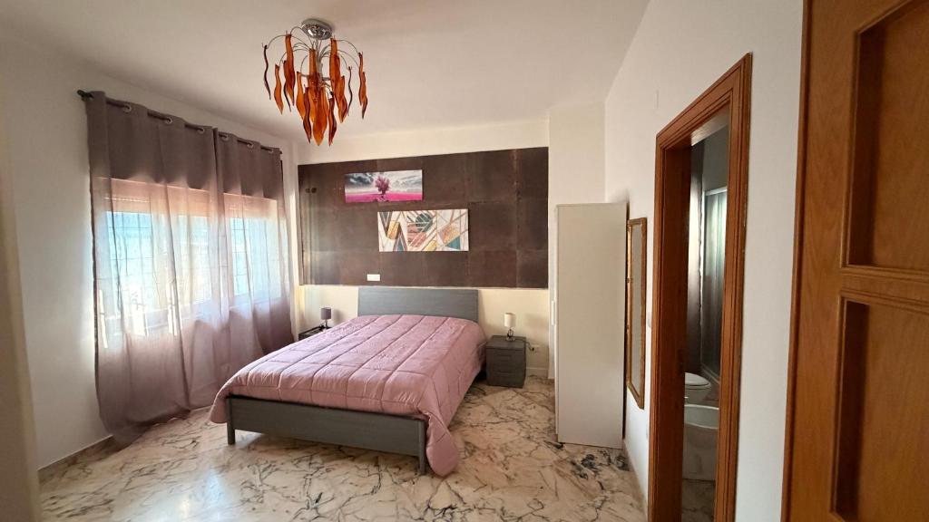a bedroom with a bed and a chandelier at Casa dell'Aloe in Angri