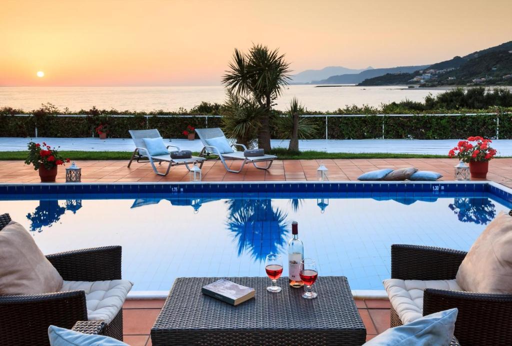 a pool with a table and glasses of wine at Simpson Secret - Epirus Coast in Ligia