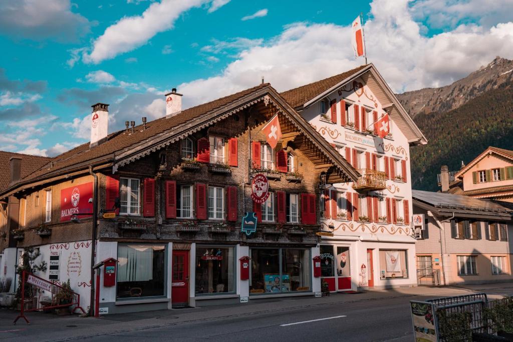 a building with red shutters on a street at Balmers Hostel in Interlaken
