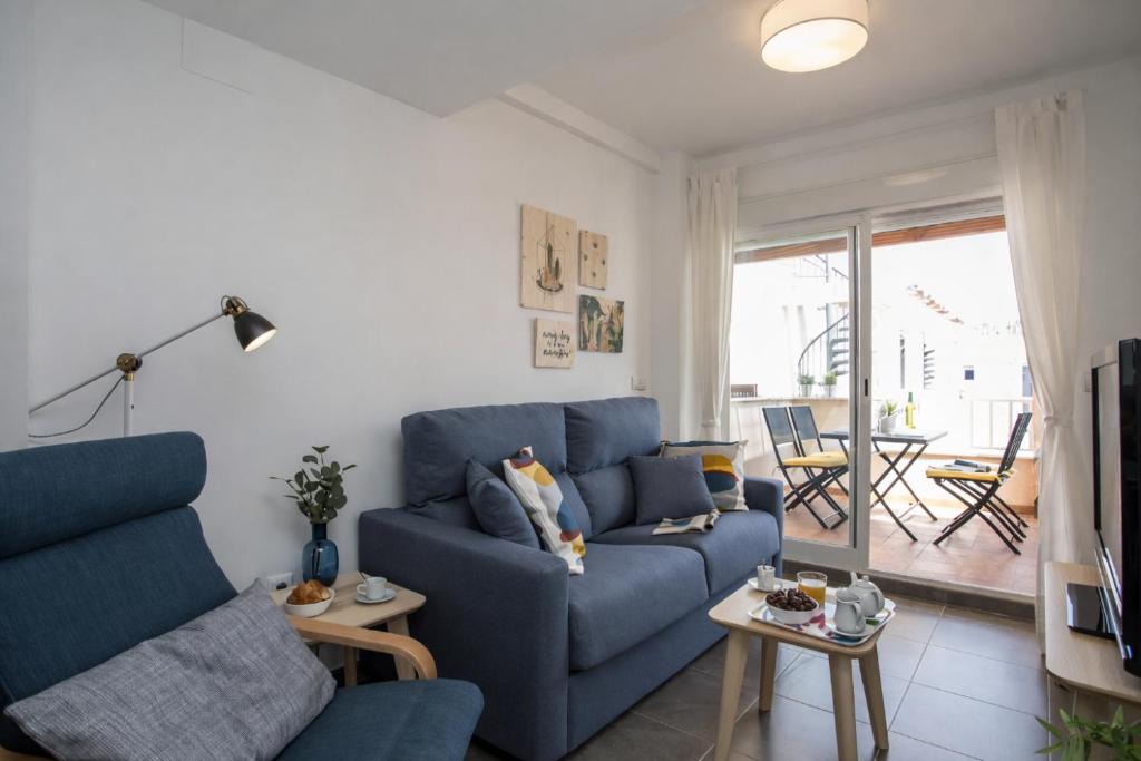 a living room with a blue couch and a tv at SingularStays Puzol Beach VI in Puzol