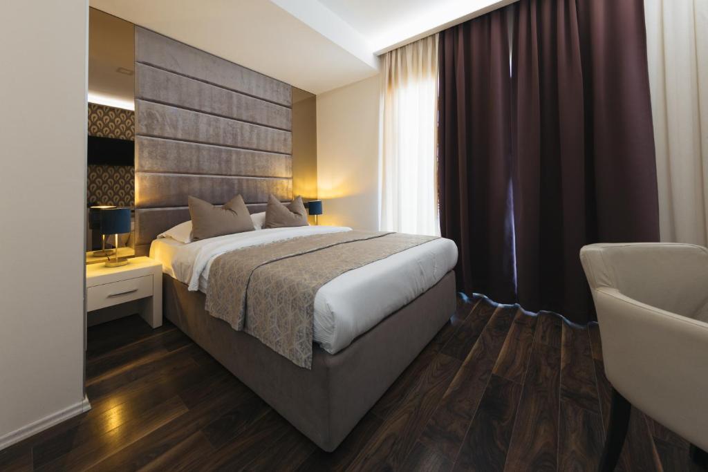 a hotel room with a bed and a chair at Hotel Villa Pace in Međugorje