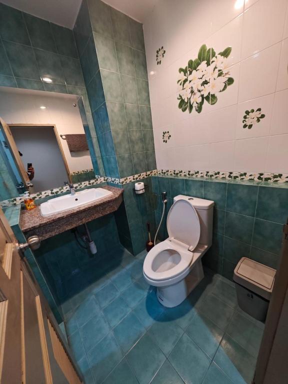 a bathroom with a toilet and a sink and a tub at Blue Apartment in Pattaya