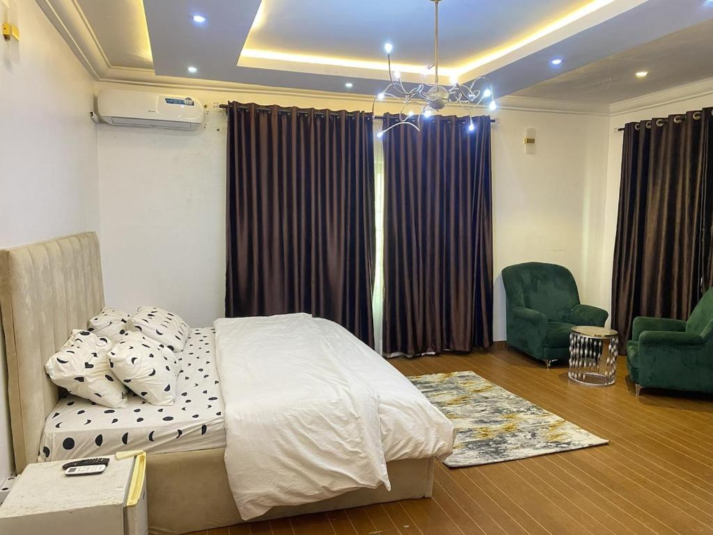 a bedroom with a bed and two chairs in it at Living Space Home in Lekki