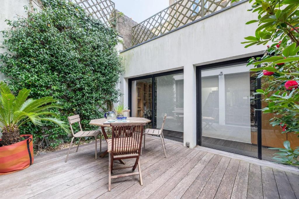 a patio with a table and chairs on a deck at Large fully renovated 250m house in Nantes