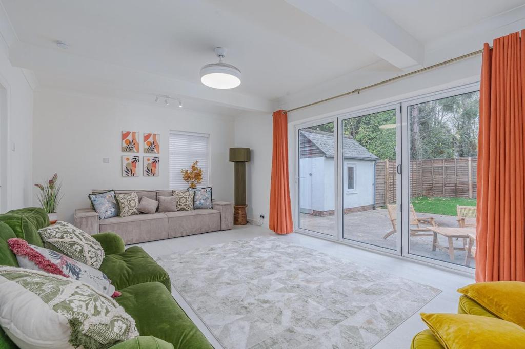 a living room with a couch and a large window at Modern 2-Bed Sleeps 5 Free Parking and Wifi near Stansted and London in Bishops Stortford