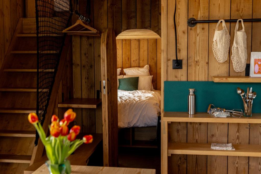 a bedroom with a bunk bed and a table with flowers at Bon Air Club in Saint-Léonard-des-Bois