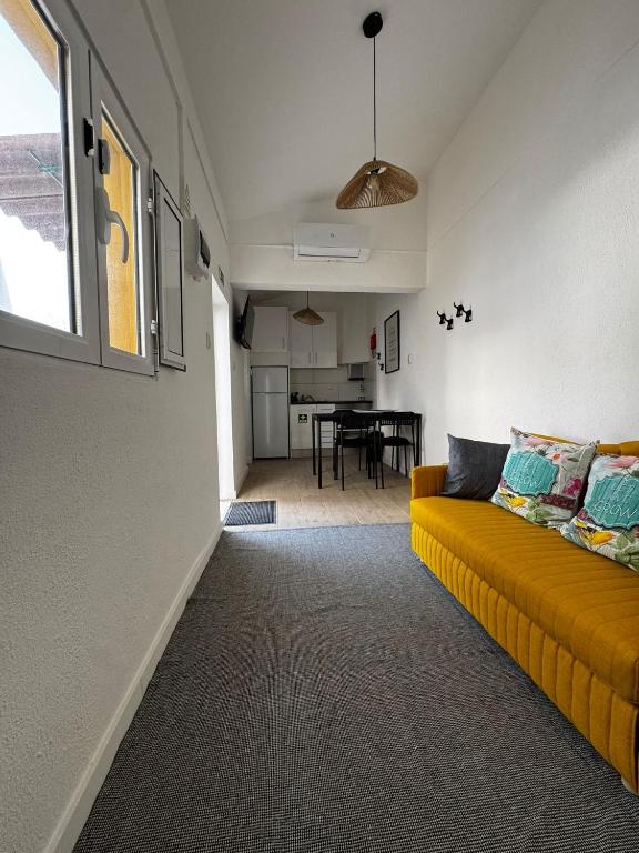 a living room with a yellow couch and a table at T'Inácia Guest House in Évora
