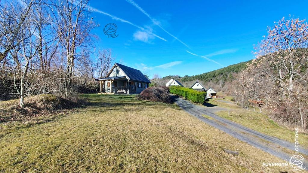 a house on a hill with a road in front of it at Chalet de la Gougère 4 in Chambon-sur-Lac