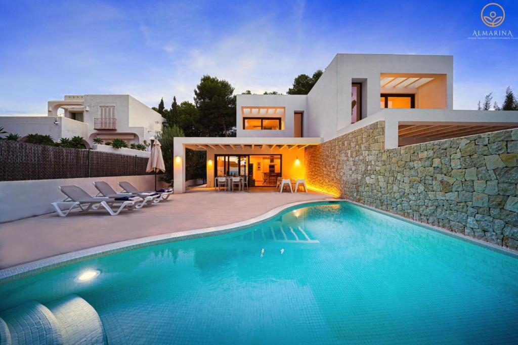 a villa with a swimming pool in front of a house at MARETA - Managed by Almarina in Teulada