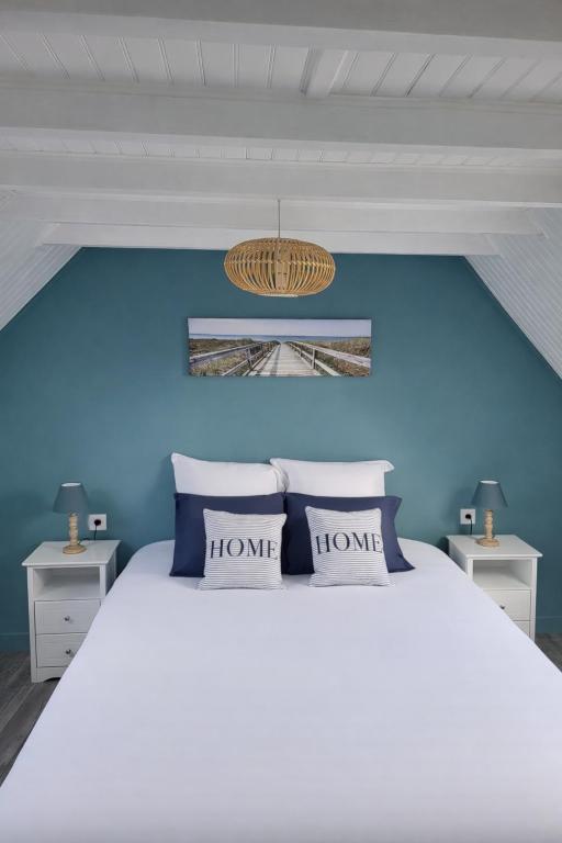 a bedroom with a bed with a blue wall at Les 3 Nuances in Saint-Suliac
