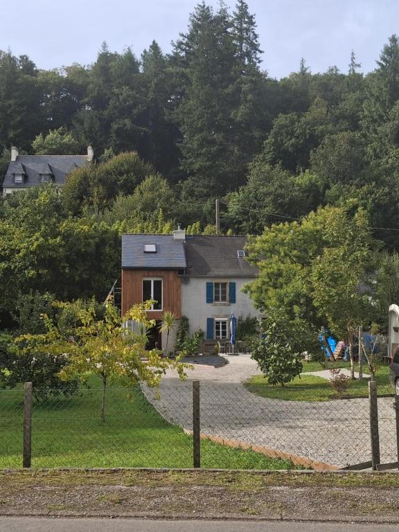 a house with a gravel driveway in front of it at Cottage en Saule in Port-Launay