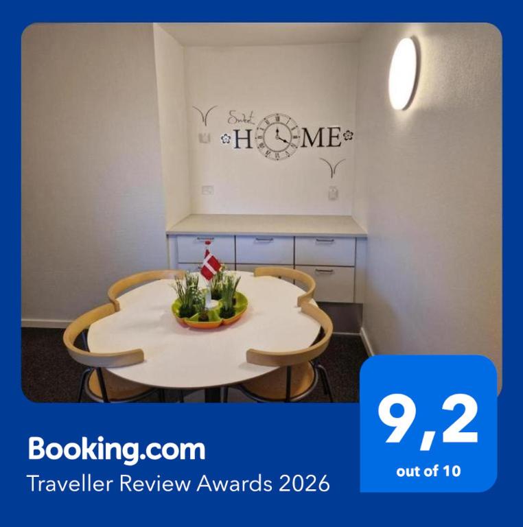 a room with a table with two chairs and a clock at Guest House Rens in Bylderup-Bov