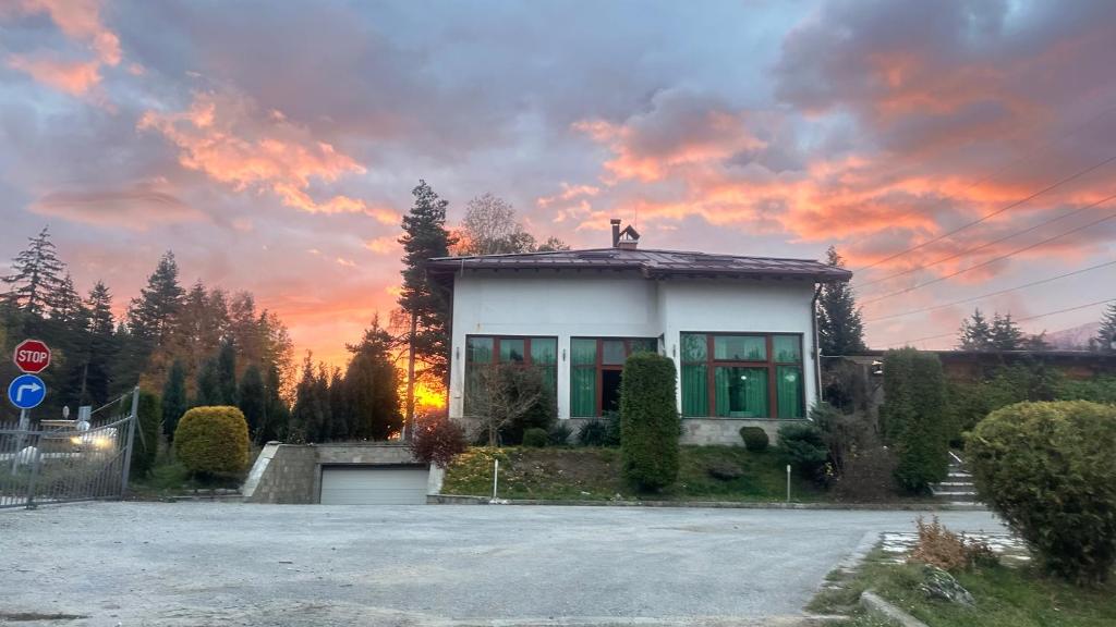 a house with a sunset in the background at Kulata Predel in Razlog