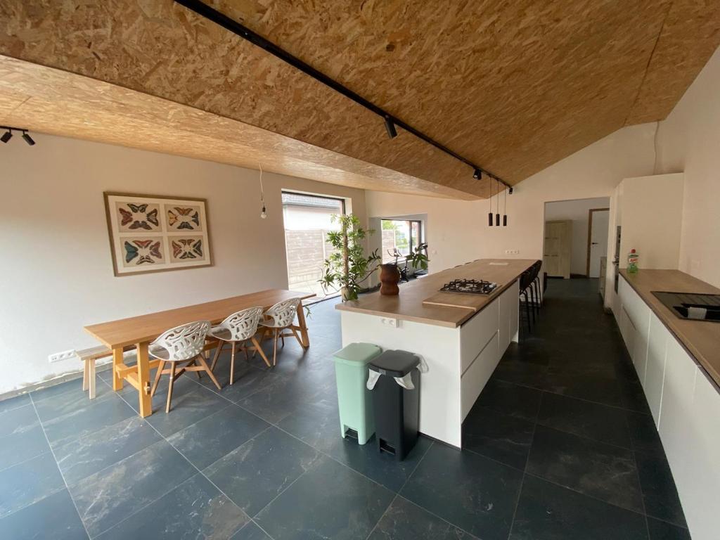 a kitchen and dining room with a table and chairs at Spacious house specially for workers and expats in Maldegem