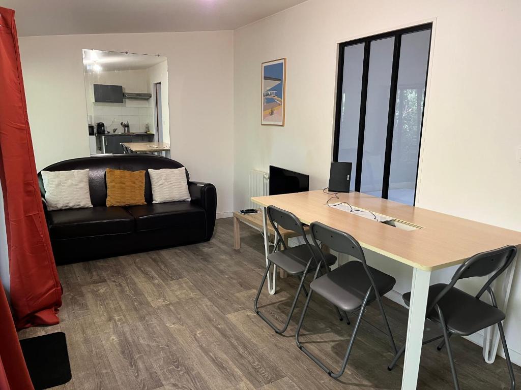 a living room with a table and a couch at T2 Côté Jardin in Eysines