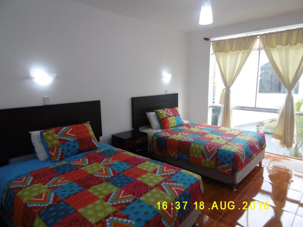 1 dormitorio con 2 camas y ventana en Hospedaje Familiar Rigimark, en Tacna
