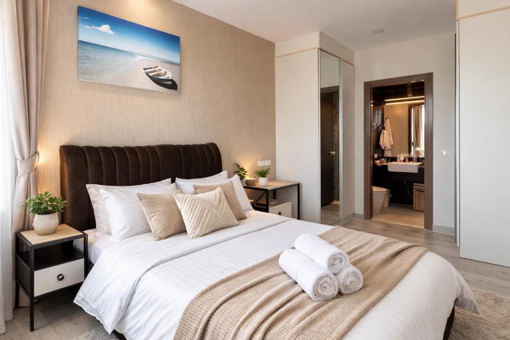 a bedroom with a large bed with towels on it at Aleksandra Royal Lee in Ban Bo Han