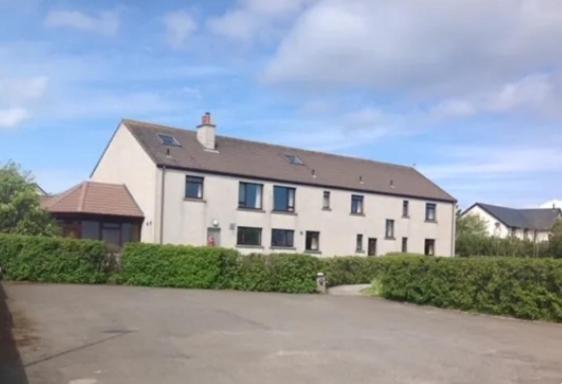 a large white house with a roof at Peedie Sea Accommodation in Orkney