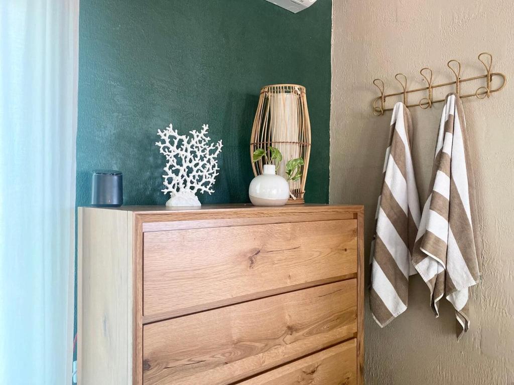 a wooden dresser with a vase on top of it at Jungle Hut - RARE absolute beachfront! in Dundee Beach