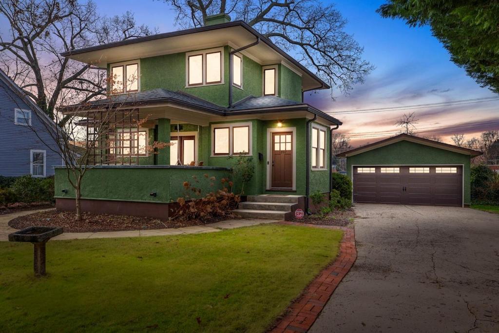 a green house with a driveway and a garage at Historic Home with King Bed in High Point