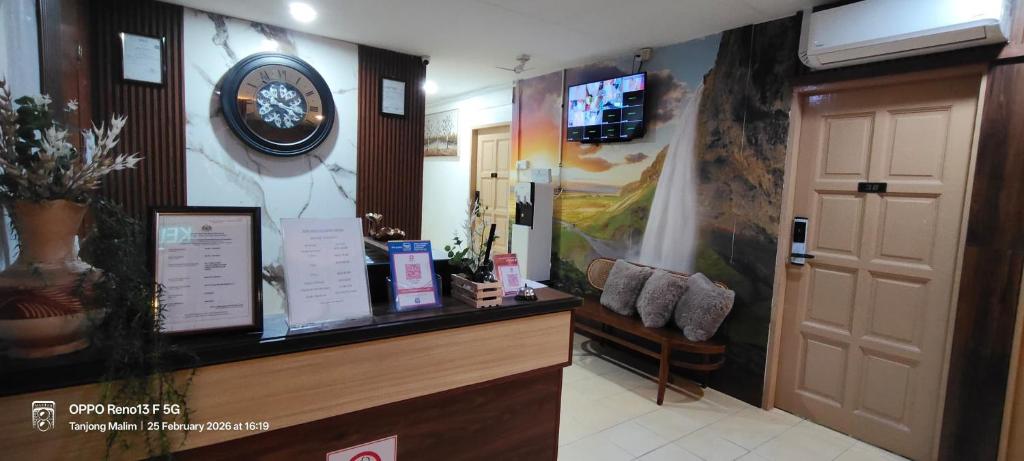 a waiting room with a clock on the wall at Tanjong Boutique Hotel in TanjongMalim