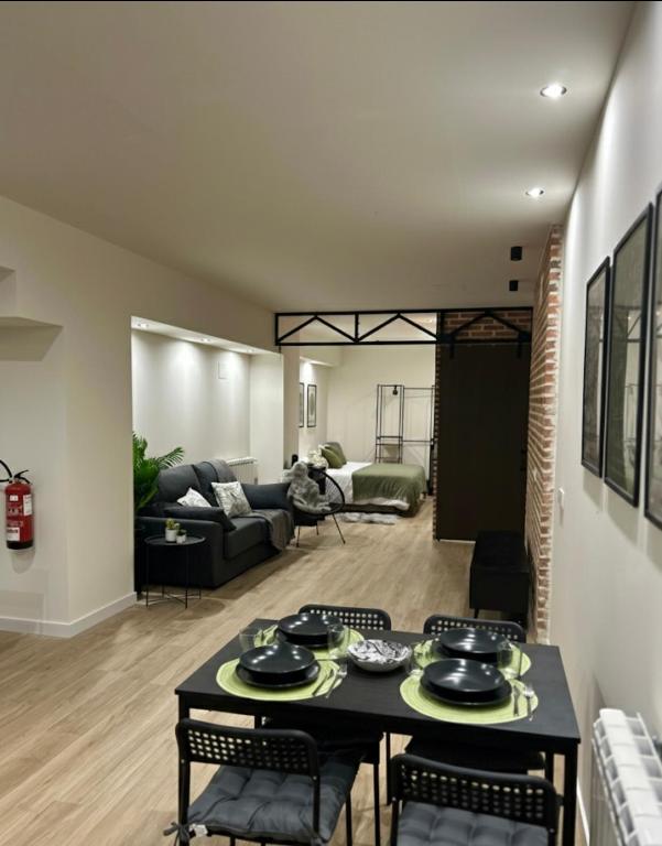 a living room with a black table and chairs at Apartamentos Bajo La Viga con Piscina in Salamanca