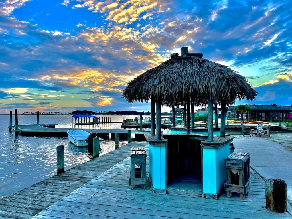 a dock with a hut and chairs on the water at Snug Harbor Marina and Resort in Chincoteague
