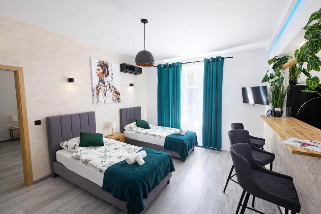 a bedroom with two beds and a table and chairs at Apartament Zacisze 2 in Przemyśl