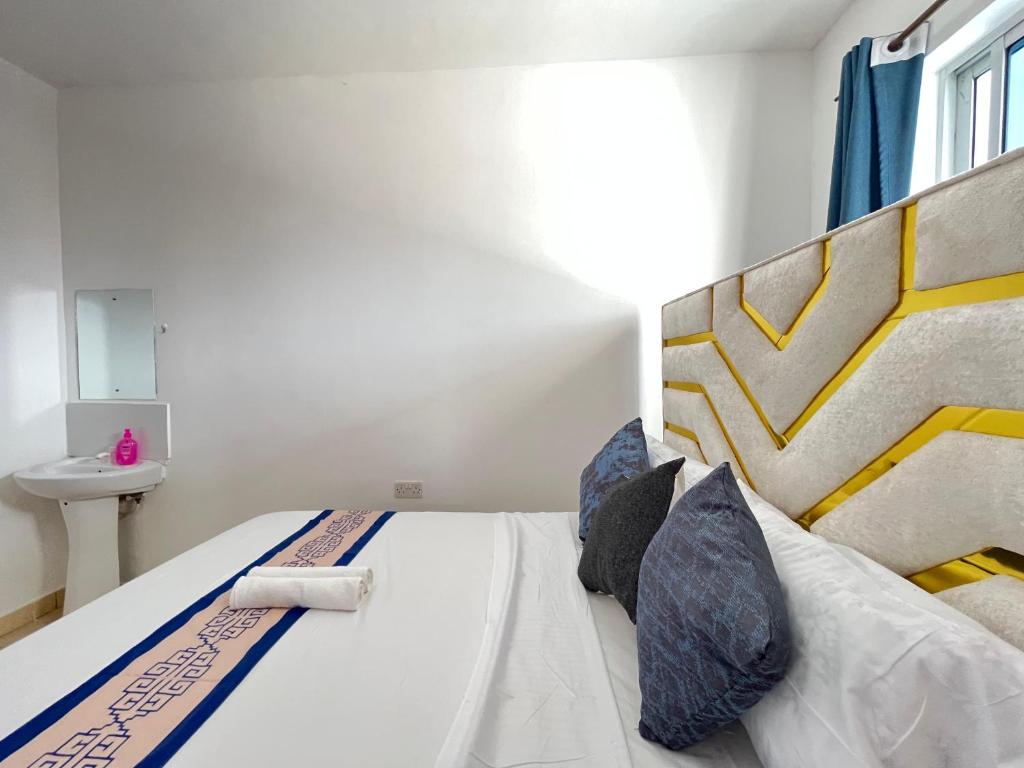 a bedroom with a large bed and a sink at Azure Stays in Mombasa