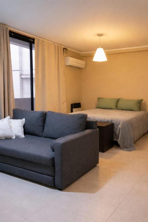 a living room with a couch and a bed at Amplio monoambiente céntrico Rafaela in Rafaela