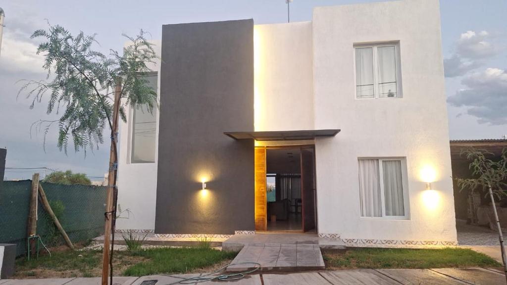 a white house with a door and a tree at Bed and breakfast Maipu in Maipú