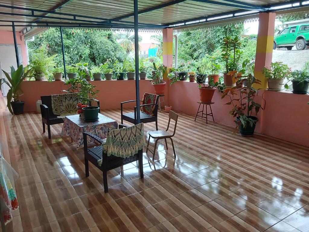 a patio with a table and chairs and potted plants at mango guest house in La Ferme