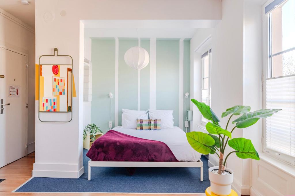 a bedroom with a bed and a potted plant at Strasbourg Evasion Pop in Strasbourg