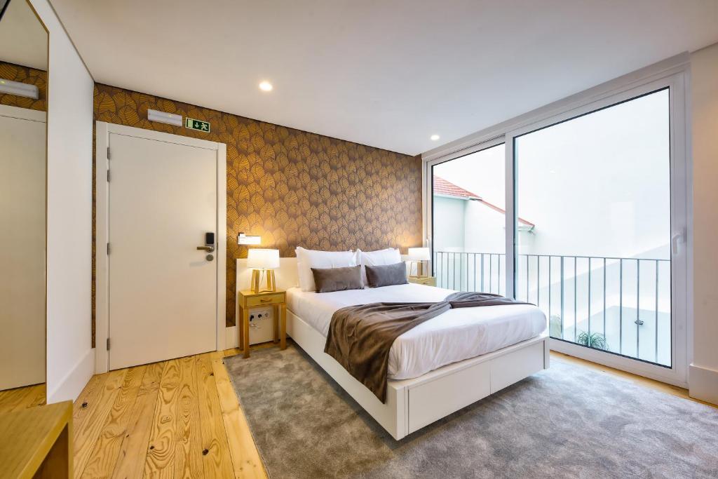 a bedroom with a large bed and a large window at Avenue Garden in Coimbra
