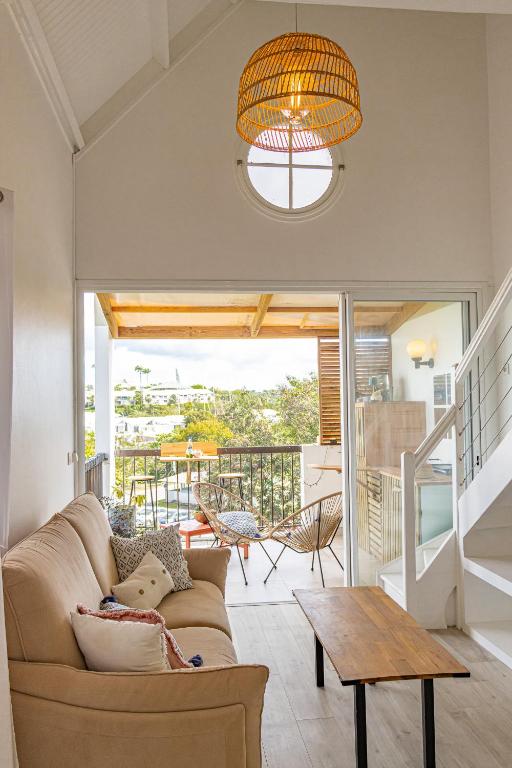 a living room with a couch and a table at Duplex mezzannine vue marina in Le Gosier