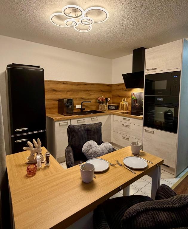 a kitchen with a wooden table with chairs and a dining room at Ferienwohnung Hopfentraum in Alpirsbach