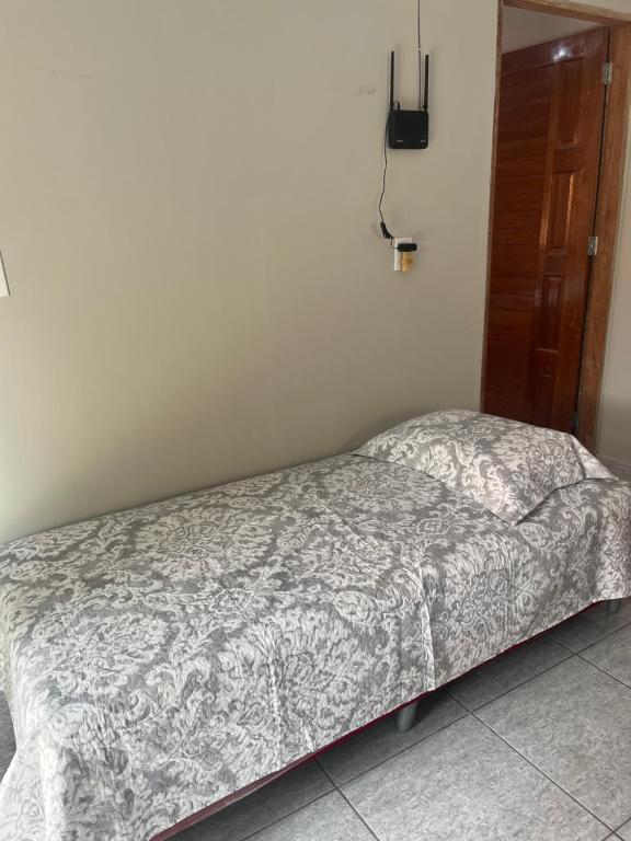 a small bed in a bedroom with a bedspread at Meu cantinho 5 in Santarém